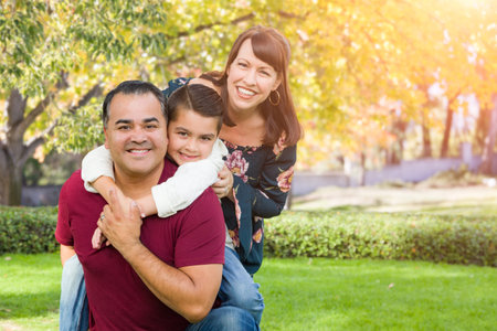 Mixed Race Young Family Portrait At The Park.