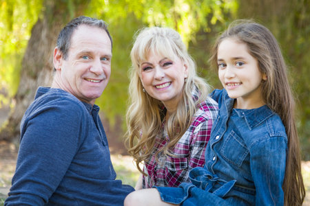 Caucasian Grandmother and Grandfather With Young Mixed Race Grandaughter Outdoors.