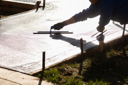 Construction Worker Smoothing Wet Cement With Trowel Toolsの写真素材