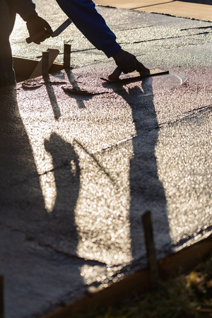Construction Worker Smoothing Wet Cement With Trowel Toolsの写真素材