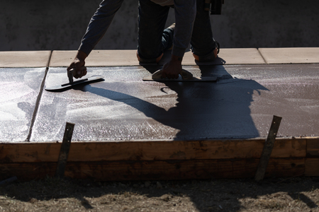 Construction Worker Smoothing Wet Cement With Trowel Toolsの写真素材