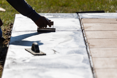 Construction Worker Smoothing Wet Cement With Hand Edger Toolの写真素材