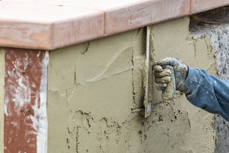 Tile Worker Applying Cement with Trowel at Pool Construction Site.の写真素材