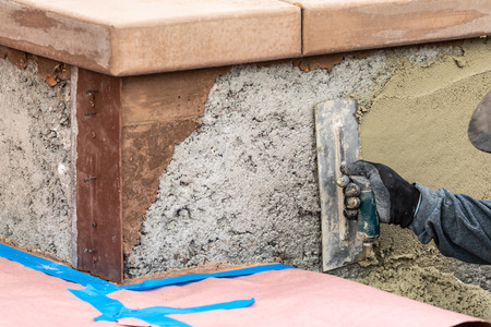 Tile Worker Applying Cement with Trowel at Pool Construction Site.の写真素材