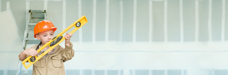 Cute Young Boy Dressed As Contractor Holding Level Against Dywall Banner Background with Ladder.