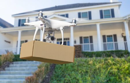 Unmanned Aircraft System (UAV) Quadcopter Drone Delivering Package To House.の写真素材