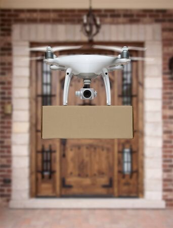 Unmanned Aircraft System (UAV) Quadcopter Drone Delivering Package To House.の写真素材