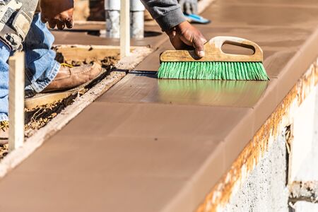 Construction Worker Using Brush On Wet Cement Forming Coping Around New Pool.の写真素材