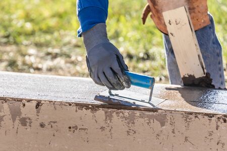 Construction Worker Using Hand Groover On Wet Cement Forming Coping Around New Pool.の写真素材