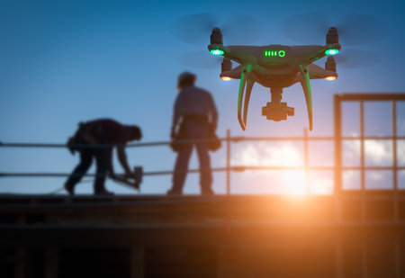Silhouette of Unmanned Aircraft System Drone (UAV) Quadcopter Drone In The Air Over Building Under...