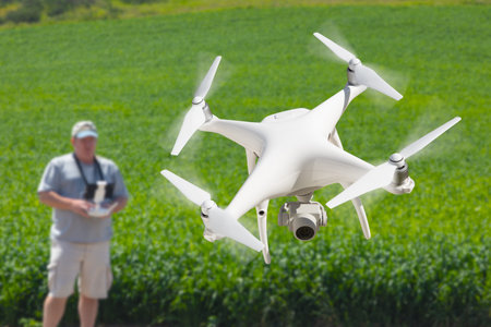 Pilot Flying Unmanned Aircraft Drone Gathering Data Over Country Farmland Field.