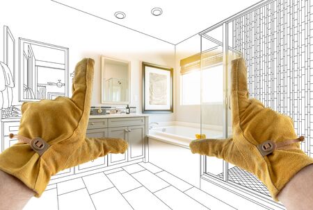 Male Contractor Hands Framing Completed Section of Bathroom Over Bathroom Drawing.の写真素材