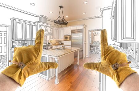 Male Contractor Hands Framing Completed Section of Custom Kitchen Design Drawing.の写真素材