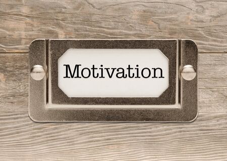 Motivation Only Metal File Label Frame on Wood Background.の写真素材
