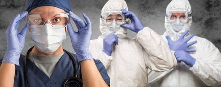 Caucasian Woman, Man and Chinese Man In Masks, Goggles and Hazmat Suites.の写真素材