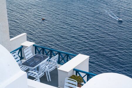 Santorini Greece Home Patio With Ocean View As Cruise Ship Tender Transports Tourists Below.の写真素材