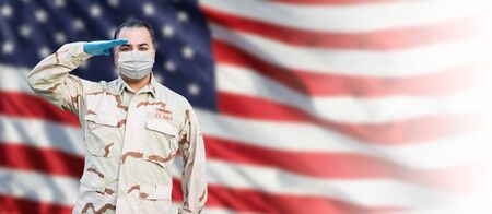 Male Navy Medical Personel Saluting Wearing Personnel Protective Equipment (PPE) With American Flag Background Banner.の写真素材