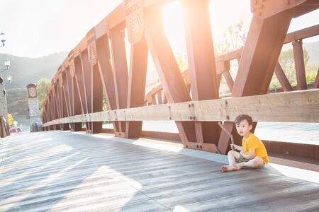 Mixed Race and Caucasian Boy Playing Alone on Bridge.の写真素材