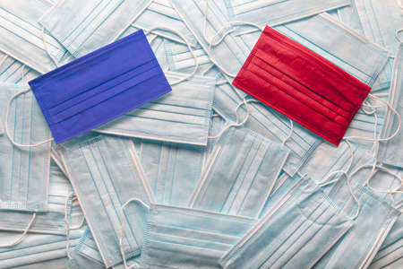 Republican Red and Democrat Blue Medical Face Masks Resting on a Pile of Other Face Masks.の写真素材