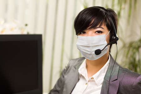 Woman At Office Desk Wearing Medical Face Mask.の写真素材