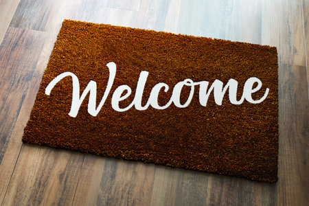 Dark Brown Welcome Mat On Wood Floor Background.