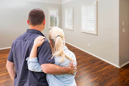 Young Couple Facing Empty Room of New House.の写真素材