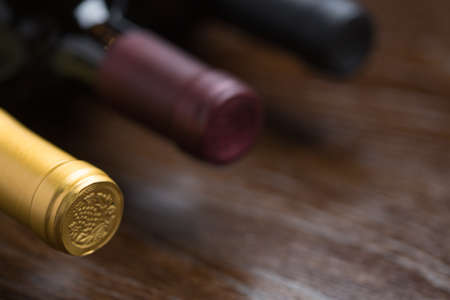 Various Wine Bottles on a Reflective Wood Surface Abstract.の写真素材