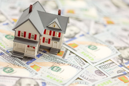 Small Model House on Layer of One Hundred Dollar Bills.