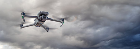 Unmanned Aircraft System (UAV) Quadcopter Drone In The Air On A Cloudy and Stormy Day.の写真素材