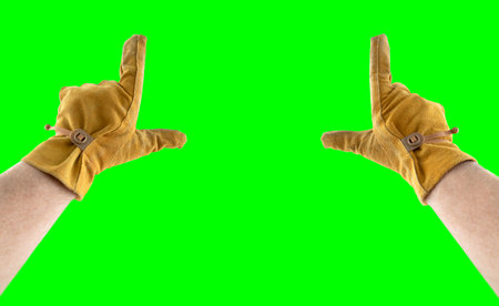Male Hands in Leather Construction Gloves Making Framing Gesture Over A Green Screen.の写真素材