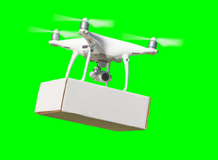 Isolated Unmanned Aircraft System (UAV) Quadcopter Drone Carrying Box Delivery In The Air Over A Green Screen.の写真素材