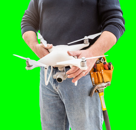 Partial View of Construction Worker Wearing Toolbelt and Holding His UAV Drone on Green Screen.の写真素材