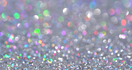 Magical festive shiny background for Christmas. Neon pastel bright magic unicorn rainbow abstract lights. Blurred colorful light dots. Dust or flying particlesの写真素材