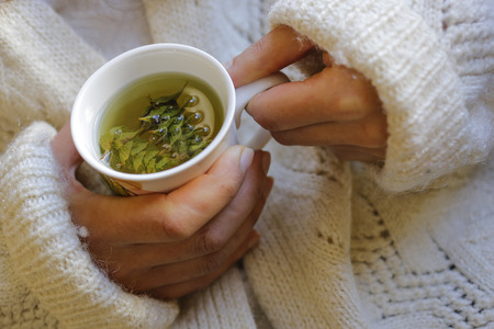 The young woman with sage tea on the hand.の写真素材