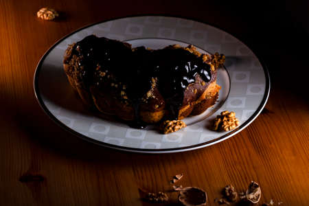 Smoky walnuts cake of chocolate sauce on the plate in low light.の写真素材