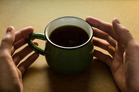 Black tea in green cup on tableの写真素材