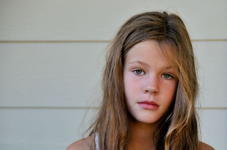 A young girl with brown hair looks at the camera.の写真素材