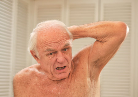 A smelly arm pit makes a man react in disgust.の写真素材