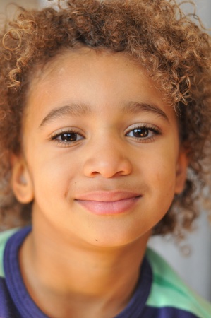 Curly hair mixed race boy posing for portraitの写真素材
