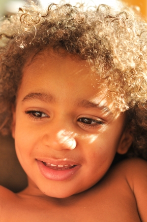 Curly hair mixed race boy posing for portraitの写真素材