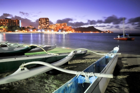 Night scene of a group of outrigger conoes on the beach with Diamond Headの写真素材