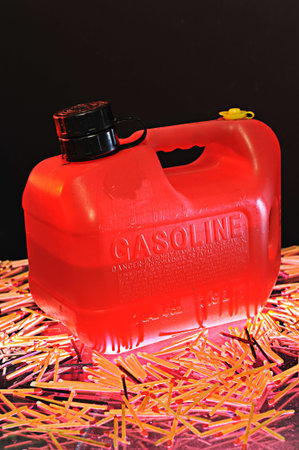 A half full container of gas is surrounded by matchesの写真素材