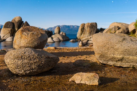 Stars in the sky at Lake Tahoe with boulders in a bayの写真素材