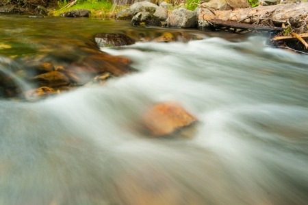 Water flows over rocks in a river  Slow shutter speed makes it look smoothの写真素材