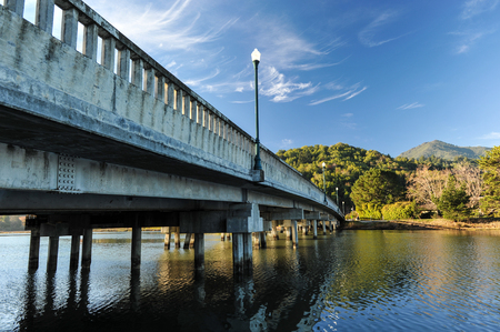 Old fashion bridge over a river with a light poleの写真素材