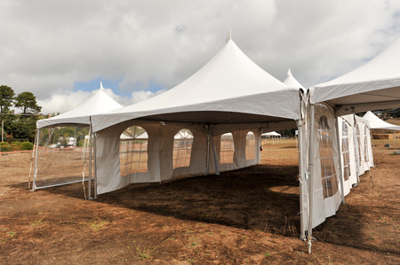 Tents in a field with some brown grass outsideの写真素材