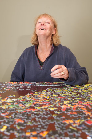 A thousand piece jigsaw puzzle put together by a blonde haired white womanのeditorial素材