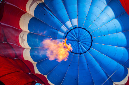 A flame fills a colorful  hot air balloonの写真素材