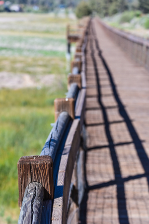 A wooden walkway bridge over Big Bear Lake with rails when the lake is 14 feet below normalの写真素材