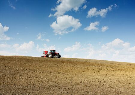 Tractor plowing field in early spring.の写真素材